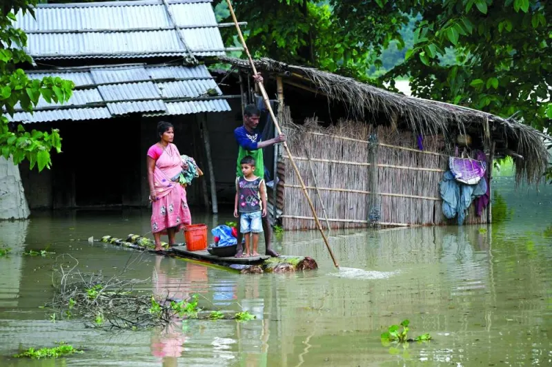 A family carries their belongings on a banana raft at the flood affected Mayong village in Morigaon district, Assam, yesterday.