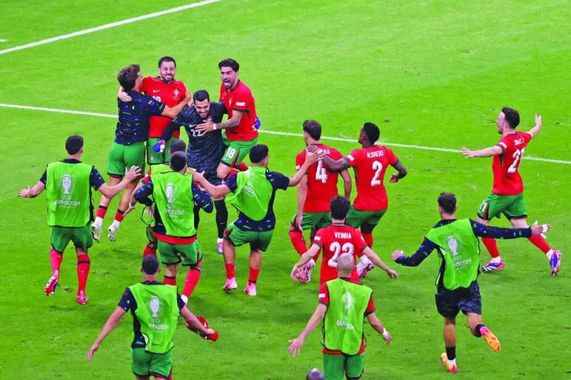 
Portugal’s players greet goalkeeper Diogo Costa (centre) after winning the match against Slovenia. (AFP) 