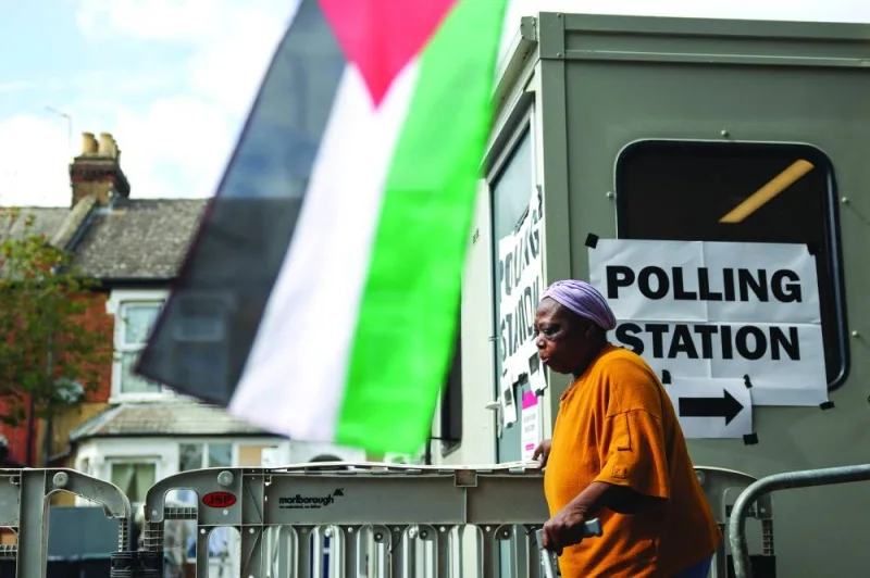 A person walks past a Palestinian flag outside a polling station in South Tottenham during the general election in London, yesterday