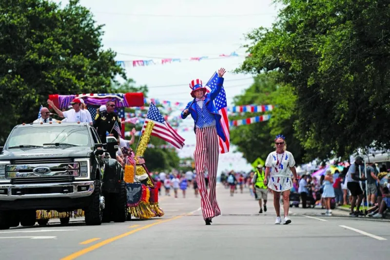 People participate in the annual Independence Day Parade yesterday in Southport, North Carolina; and Washington DC, right. (AFP)