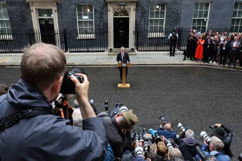 Photographers take pictures as British Prime Minister Keir Starmer delivers his speech outside Number 10 Downing Street, following the results of the election, in London, Friday. REUTERS