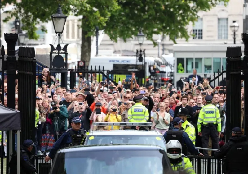 People gather as the motorcade transporting new British Prime Minister Keir Starmer arrives at Downing Street, following a parliamentary election, in London, Friday. REUTERS
