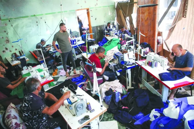 
Palestinian tailors work in a newly reopened sewing factory after the machines were retrieved from a building hit in an Israeli strike, amid the conflict, in Khan Younis in the southern Gaza Strip. 