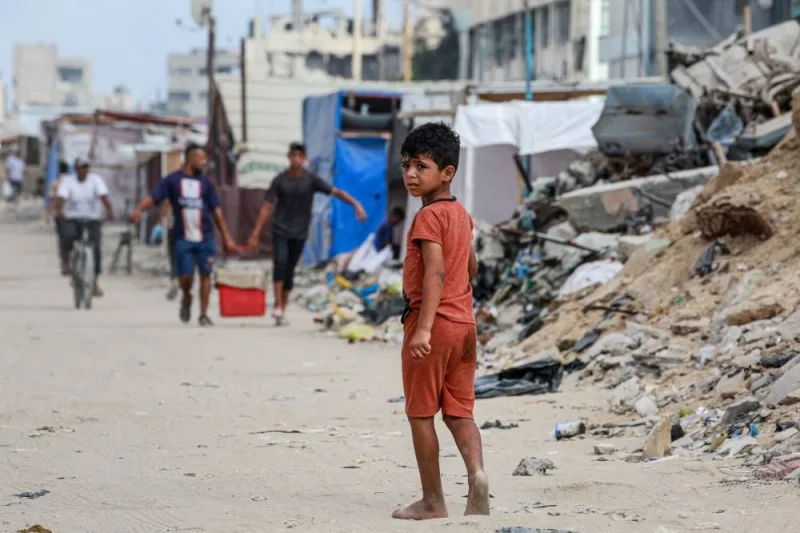 A Palestinian child walks along street riddled with rubbish and rubble in Khan Yunis, on the southern Gaza Strip on Saturday. AFP