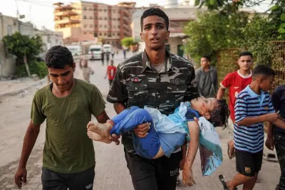 The body of a child killed by Israeli bombardment is carried towards the morgue of Nasser Medical Complex in Khan Yunis in the southern Gaza Strip on Friday. AFP