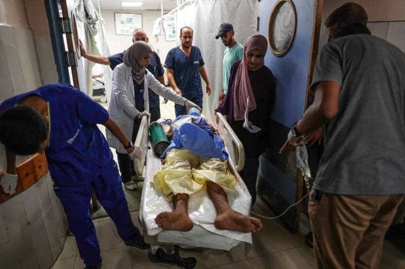 Medics give aid to a man lying a gurney, injured during Israeli bombardment, as he is brought to the Nasser Hospital in the city of Khan Yunis, on Saturday. AFP