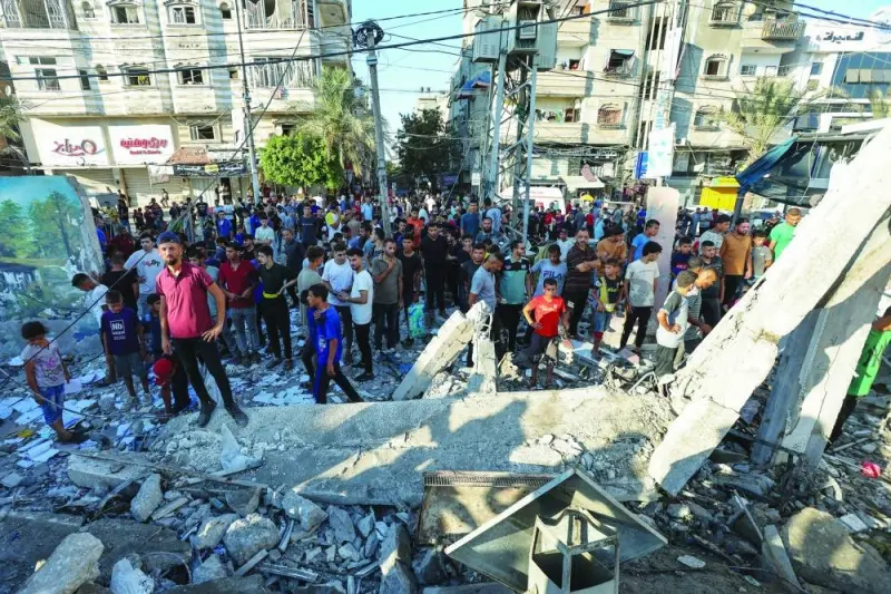 Palestinians gather at the site of an Israeli air strike on a UN school in Nusairat in central Gaza Strip, Saturday.