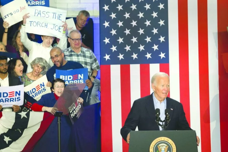 
An audience member holds a sign calling on President Joe Biden to “pass the torch” during a campaign rally at Sherman Middle School in Madison, Wisconsin. (AFP) 