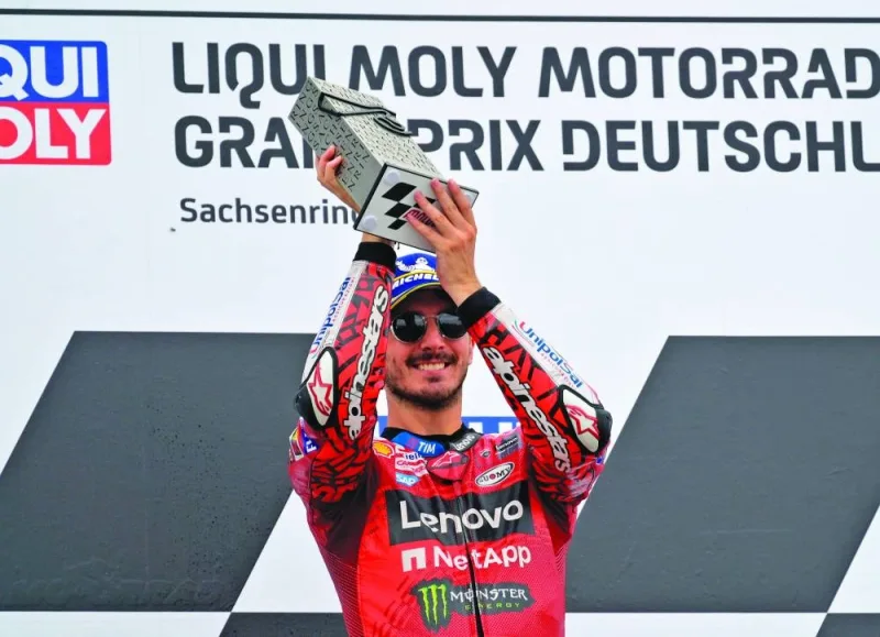 Ducati Lenovo Team’s Francesco Bagnaia celebrates with a trophy on the podium after winning the German Grand Prix at Sachsenring, Hohenstein-Ernstthal, Germany, yesterday. (Reuters)