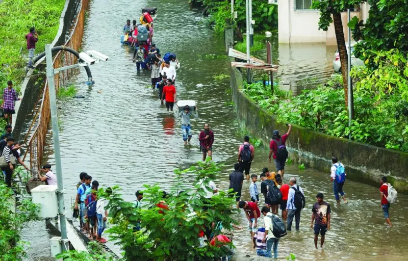 
People walk on a waterlogged street after heavy rains in Mumbai, India, yesterday. 