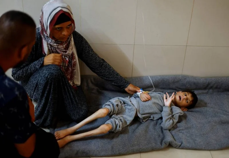 Palestinian mother Ghaneyma Joma sits next to her malnourished son Younis Joma as he receives treatment at Nasser hospital in Khan Younis, in the southern Gaza Strip, Monday. REUTERS