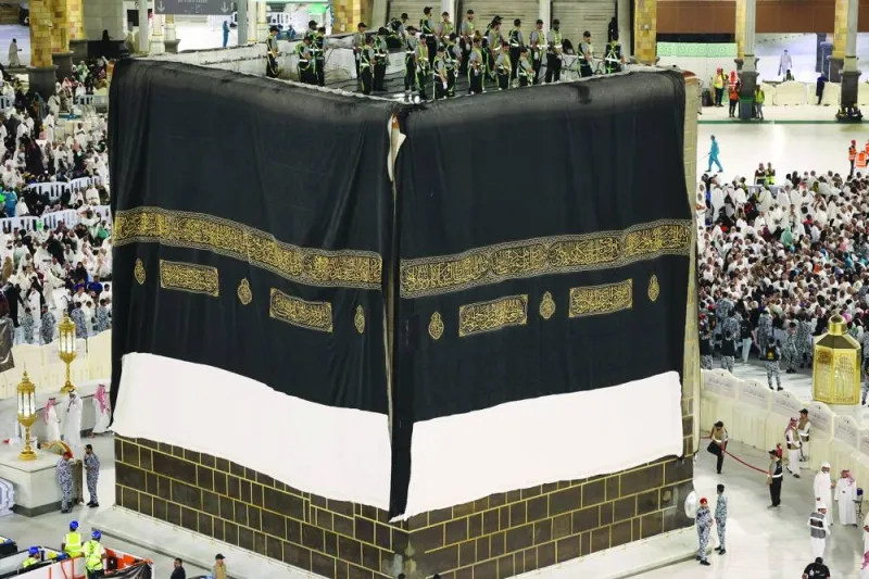 Saudi workers adjust the new Kiswa cover that adorns the Holy Ka&#039;aba.
