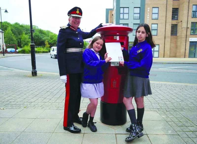 
Pupils from the Vine Inter-Church Primary School Ankita Ghosh and Miriam Miller and Lord Lieutenant of Cambridgeshire Julie Spence pose for a photocall with the first postbox bearing the cypher of Britain’s King Charles, in Great Cambourne, Britain. 