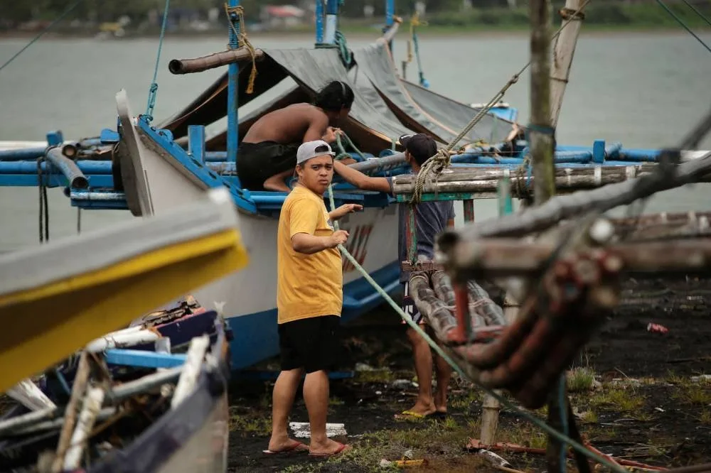 Residents secure their fishing boats at a village in Legaspi City, Albay province, south of Manila, on September 25, 2025, ahead of Tropical Storm Bualoi's landfall in the Bicol region. The Philippines shut schools and scrapped flights on September 25 as a fresh storm threatened to hit just days after a super typhoon killed nine people in the archipelago. (Photo by CHARISM SAYAT / AFP)