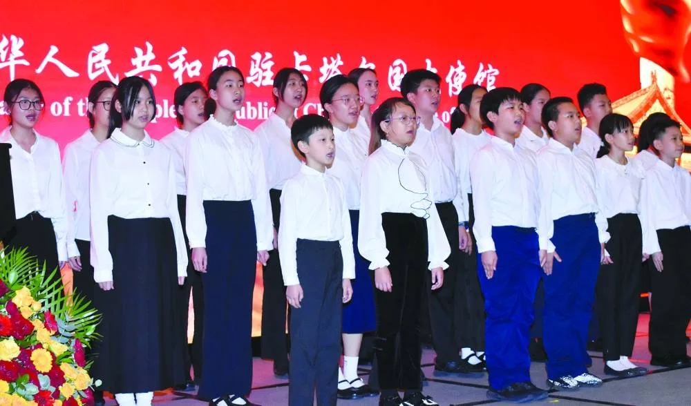 Chinese children singing the Qatari and Chinese anthems.