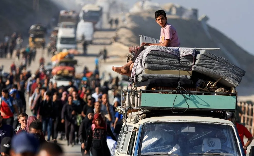A Palestinian boy sits atop of a vehicle carrying belongings, as he and other Palestinians, who were displaced to the southern part of Gaza at Israel's order during the war, make their way along a road as they return to the north, amid a ceasefire between Israel and Hamas in Gaza, in the central Gaza Strip, on Saturday. REUTERS