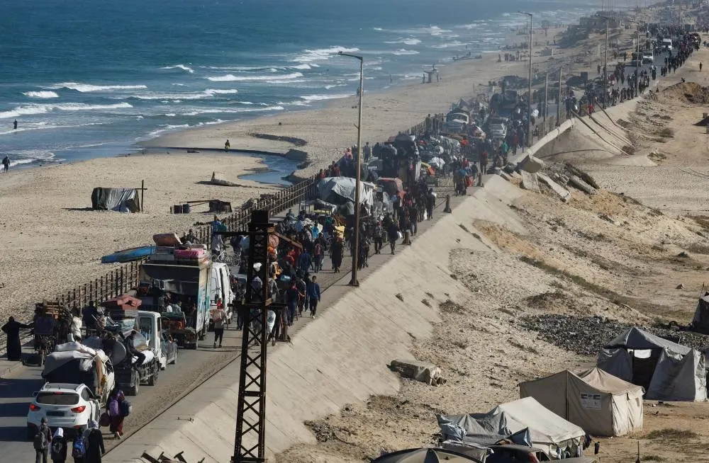 Palestinians, who were displaced to the southern part of Gaza at Israel's order, make their way along a road as they return to the north, amid a ceasefire between Israel and Hamas in Gaza, in the central Gaza Strip, on Saturday. REUTERS