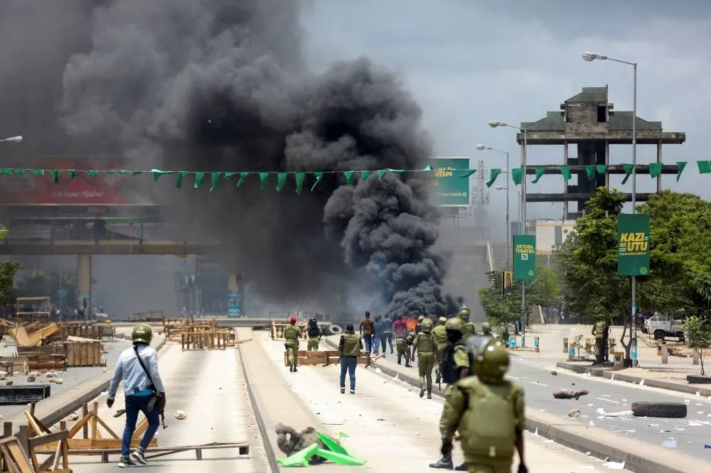 Tanzanian riot police disperse demonstrators during violent protests that marred the election following the disqualification of the two leading opposition candidates in Dar es Salaam, Tanzania, on Wednesday. REUTERS