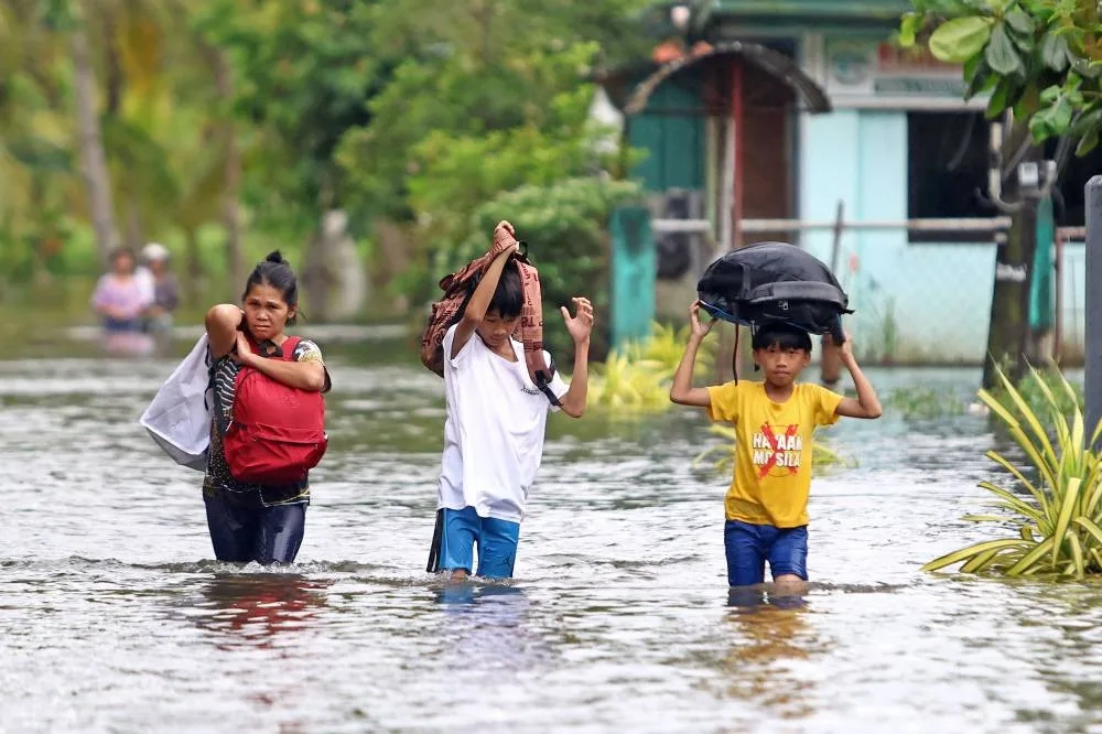 Residents evacuate from their flooded homes due to heavy rain brought by Typhoon Fung-wong in Remedios T. Romualdez, on the southern island of Mindanao in the Philippines Saturday.