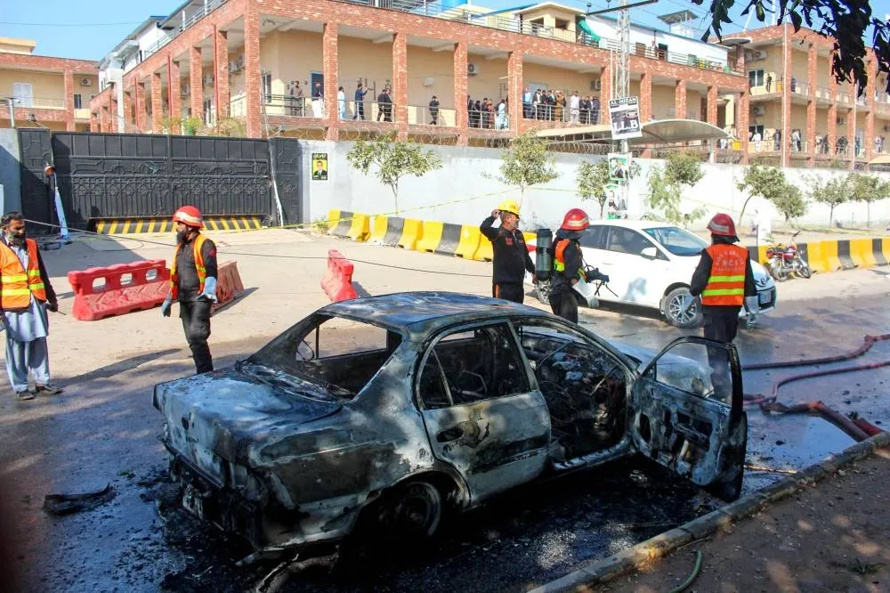 Firefighters douse a car at the suicide blast site in Islamabad on November 11, 2025. A suicide bombing outside district court buildings in a residential area of the Pakistani capital killed 12 people and wounded 27 on November 11, the interior minister said. ( AFP)