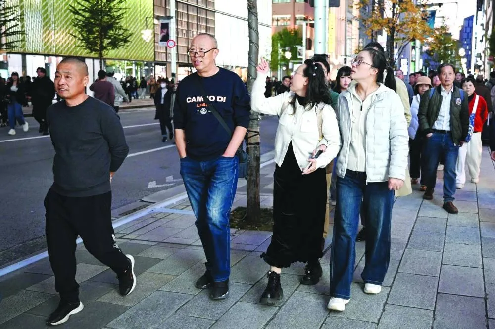 Chinese tourists walk in the Ginza shopping district in Tokyo Saturday.