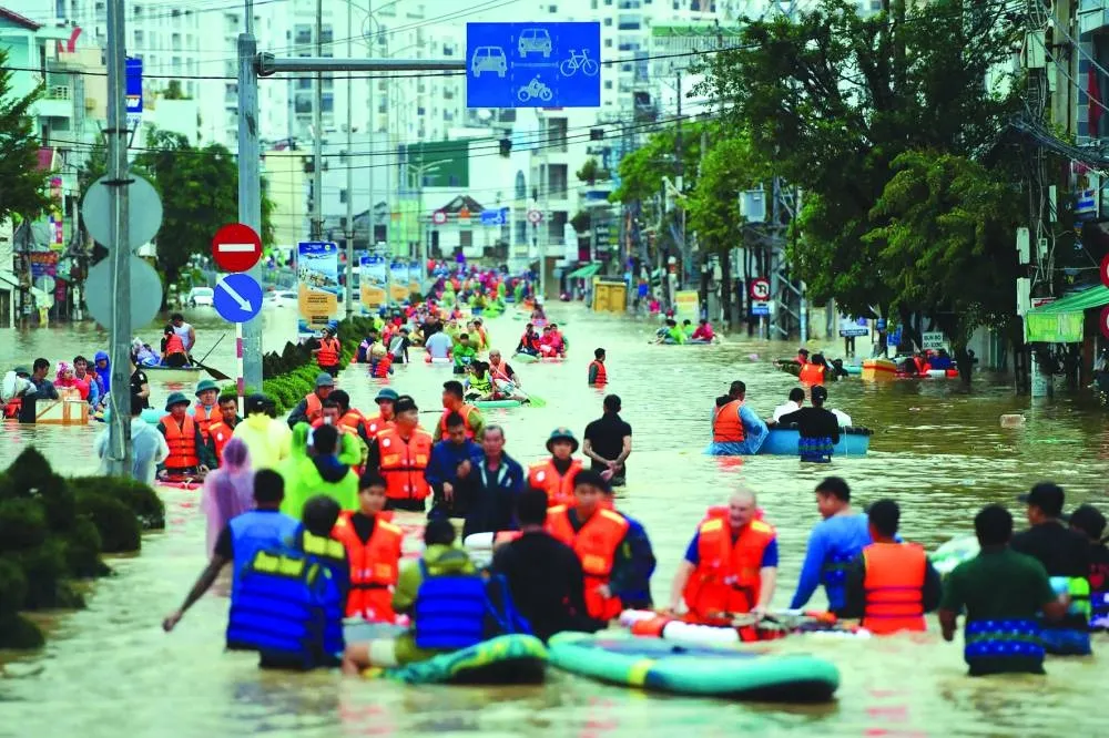 This photo taken on November 20, 2025 shows people wading through floodwaters in Nha Trang in Vietnam's coastal province of Khanh Hoa. Rescuers raced to find more than a dozen people still missing on November 22 after a week of heavy flooding in Vietnam, where authorities said at least 55 people have died. (AFP)