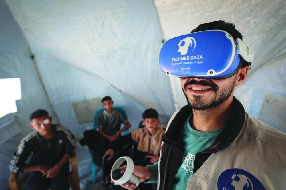 A medical technology support team member demonstrates to Palestinian youth, how to use virtual reality goggles and a joystick, as part of a medical technology initiative in the city of Al-Zawayda, in the central Gaza Strip, featuring therapy sessions using virtual reality technology.