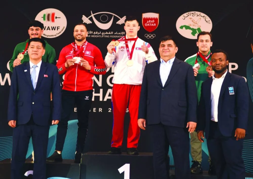 Gold medal winning weightlifter North Korea’s Ri Chong-song is seen with fellow podium winners in Doha Tuesday.