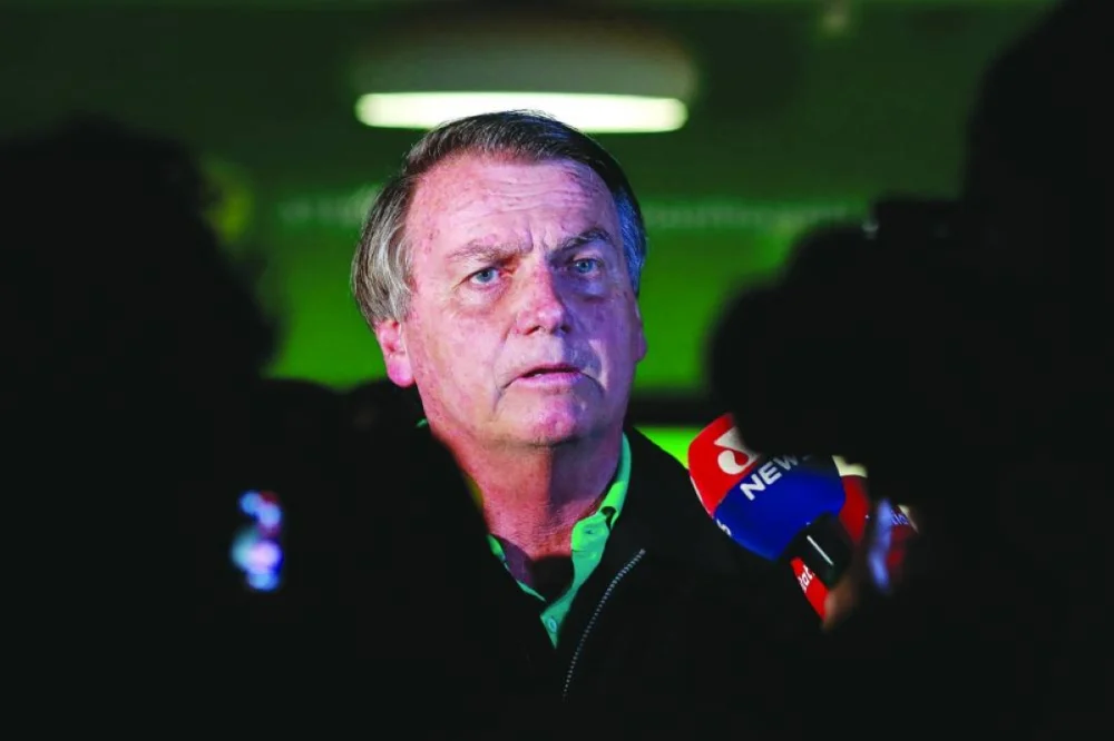 (FILES) Brazilian former President, Jair Bolsonaro, speaks to the press at the Juscelino Kubitschek International Airport in Brasilia on June 30, 2023. Brazil's Federal Police suspects Jair Bolsonaro's aides of having resold gifts received from foreign countries, including jewelry, for the "illicit enrichment" of the far-right ex-president, judicial sources said on August 11, 2023. Elements of the police investigation were published in a ruling by Supreme Court judge Alexandre de Moraes to justify search warrants at the homes of former aides to Bolsonaro. (AFP)