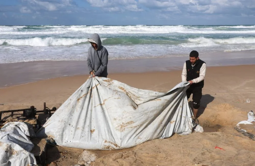 Displaced Palestinians pull out a collapsed tent at a beach tent camp, after it was flooded by rising seawater during a winter storm in Khan Younis, southern Gaza Strip, December 28, 2025. REUTERS