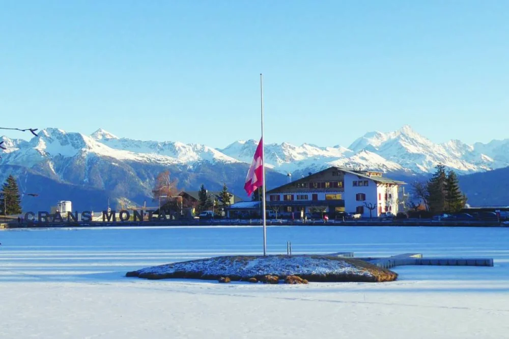 A photo shows the Swiss flag flying at half-mast following a fire at Le Constellation, in the Alpine ski resort town of Crans-Montana. – AFP