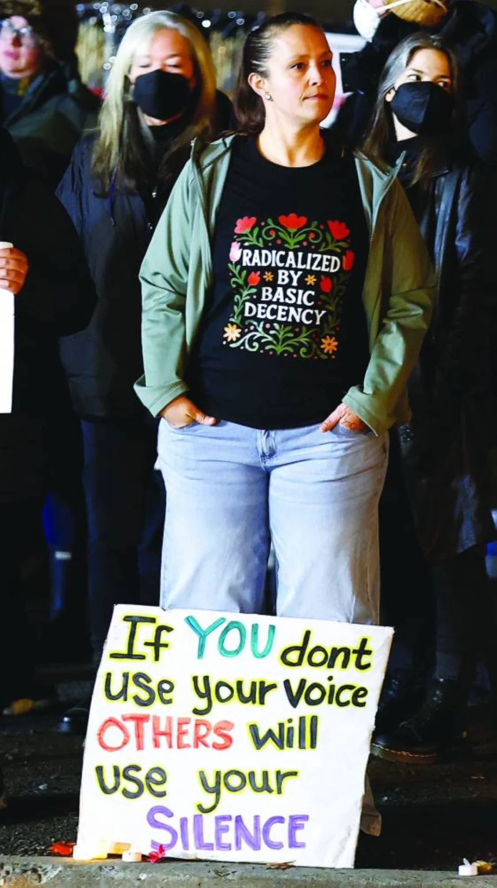 A woman with a sign beside her feet takes part in a protest outside the ICE facility in Portland, Oregon, US. – Reuters