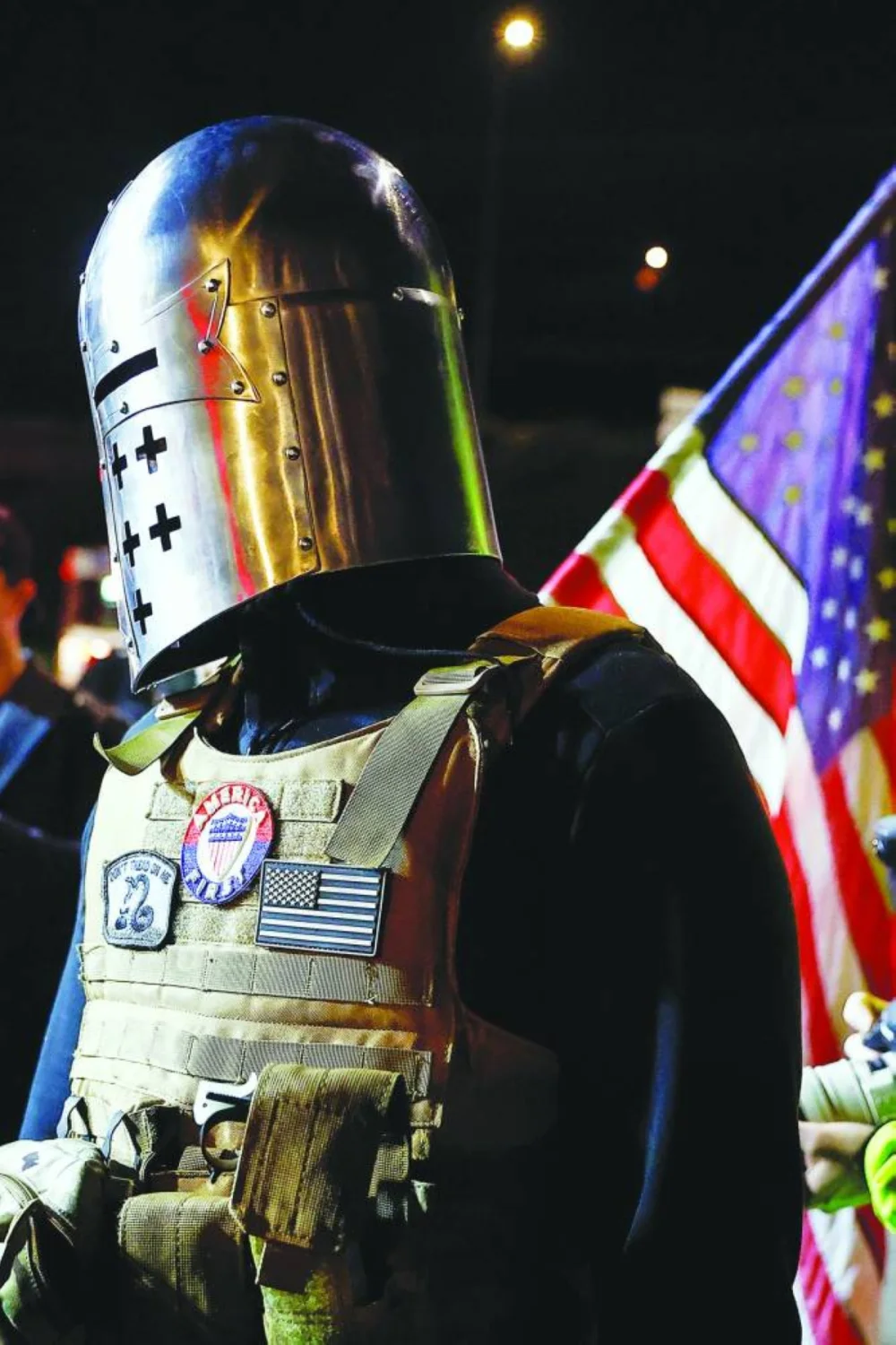 A counter-protester wearing a mediaeval helmet shouts at protesters who gathered during a vigil outside the Portland ICE facility. – Reuters