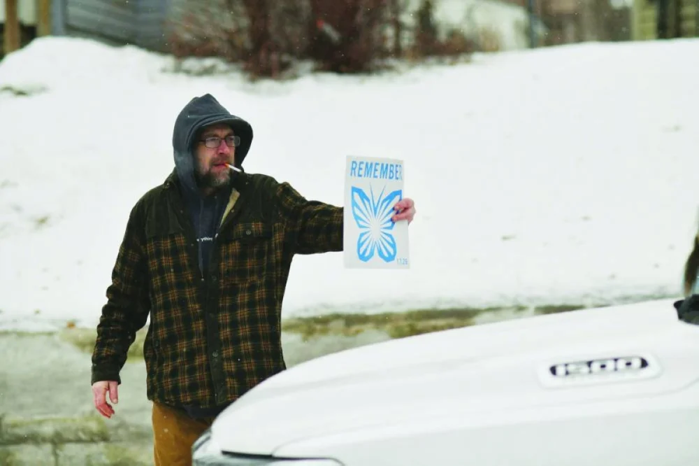 A man shows federal agents sitting in their parked truck a sign reading ‘Remember’ in the Frogtown neighbourhood in St Paul, Minnesota. AFP