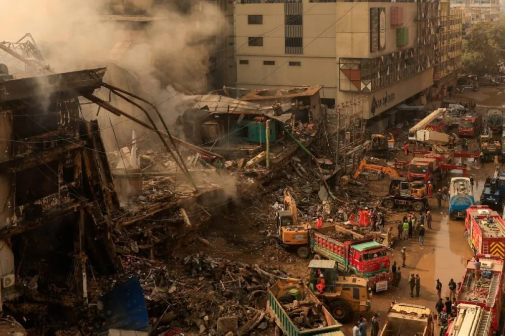 Rescue workers use heavy machinery to remove rubble from the Gul Plaza Shopping Mall in Karachi. – Reuters