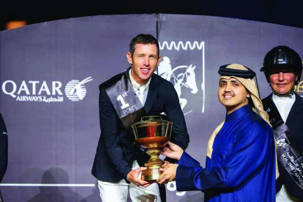 His Excellency Sheikh Thani bin Hamad bin Khalifa al-Thani, Chairperson of the Qatar Fund for Development, presents the trophy to CSI5* Grand Prix winner Scott Brash.