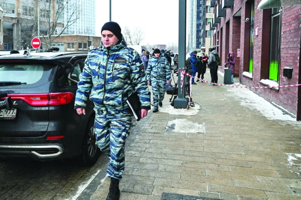 
Police officers walk past a high-rise residential building, the scene of an assassination attempt on Russian Lieutenant General Vladimir Alekseyev. 