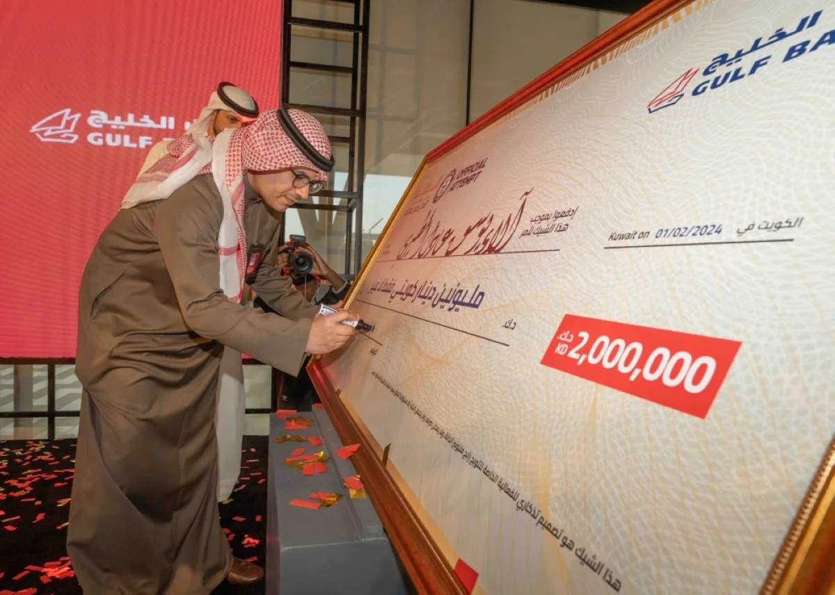 Mohammed Al-Qattan signs a cheque with the name of the winner.