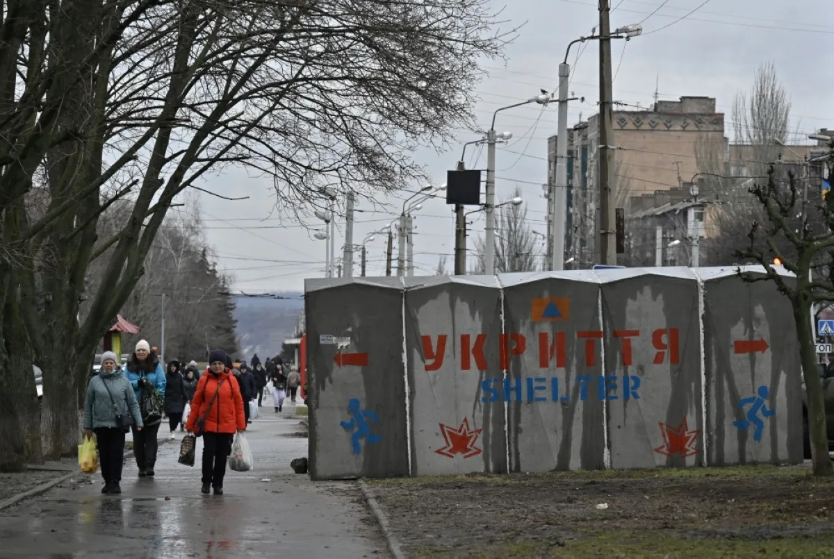 People walk past a reinforced shelter on a street of the Kramatorsk, Donetsk region on Feb 4, 2024, amid the Russian invasion of Ukraine. -- AFP