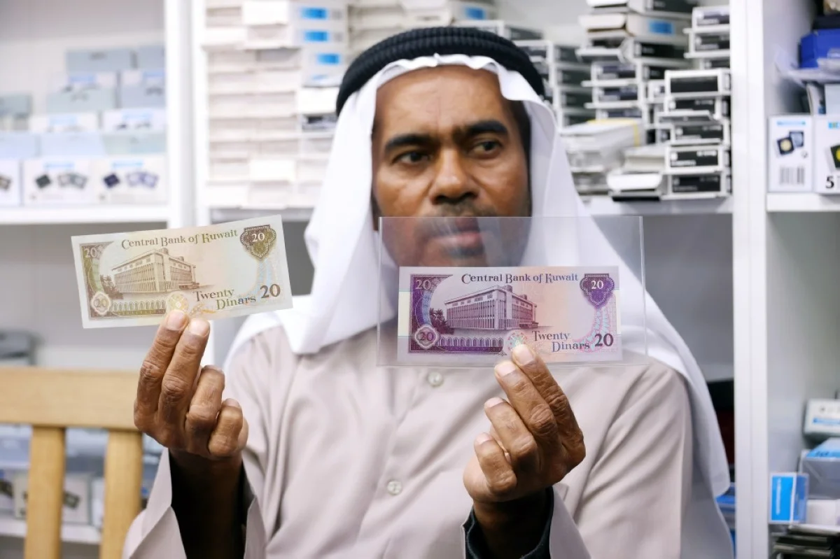 Bassem Al-Ibraheem holds the third and fourth issues of Kuwaiti dinars. - Photos by Yasser Al-Zayyat