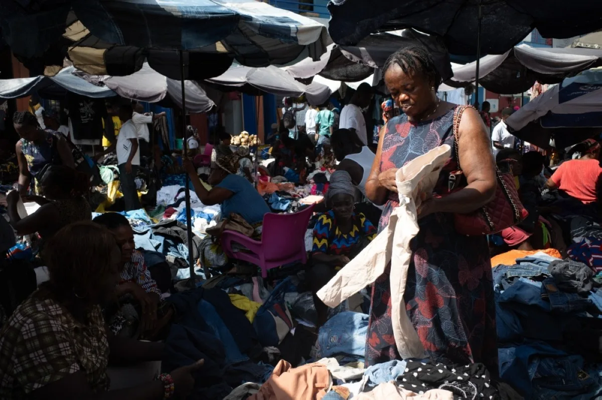 ACCRA: A buyer looks at secondhand clothes at the Kantamanto market in Accra, Ghana.- AFP