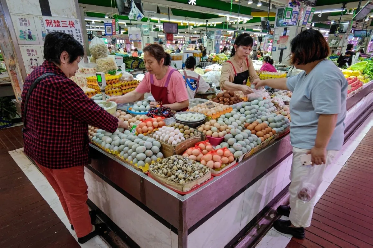 WUHAN: Customers select eggs at a market in Wuhan, in central China’s Hubei province on April 16, 2024. – AFP