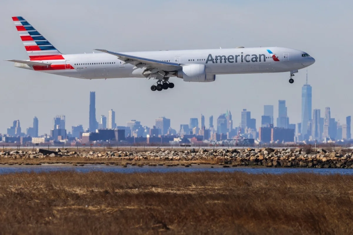 NEW YORK: A Boeing 777 passengers aircraft of American Airlines arrives from Miami at JFK International Airport in New York as the Manhattan skyline looms in the background.- AFP