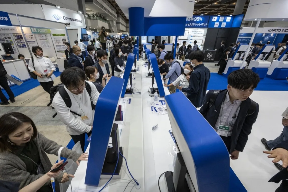 TOKYO: Visitors look at screens displaying Japanese company Tomorrow Net’s navigation-type AI communication tool ‘CAT.AI’ with a ChatGPT function during the AI Expo, part of NexTech Week, Japan’s largest trade show for artificial intelligence technology companies in Tokyo.- AFP