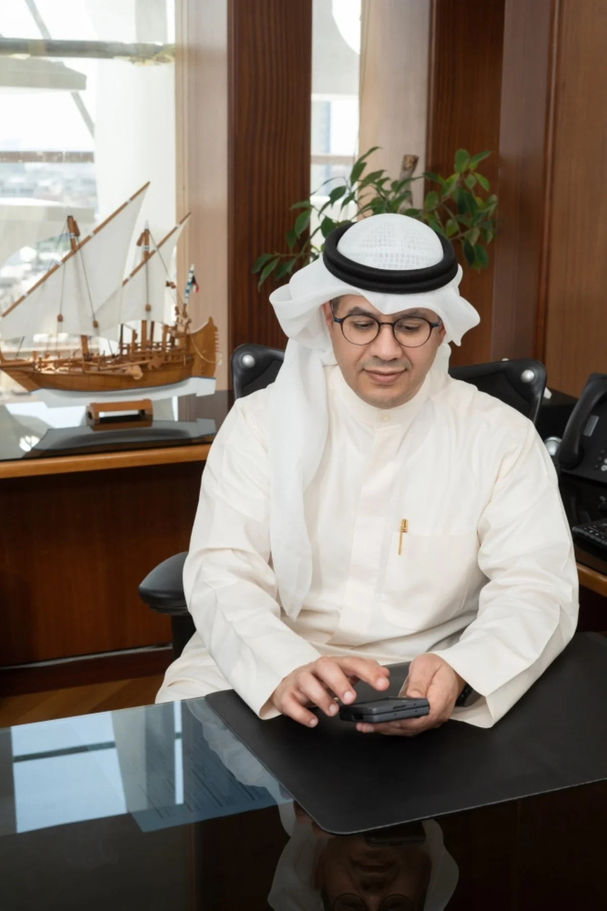 Mohammad Al-Qattan reviewing the quality services on the mobile app.