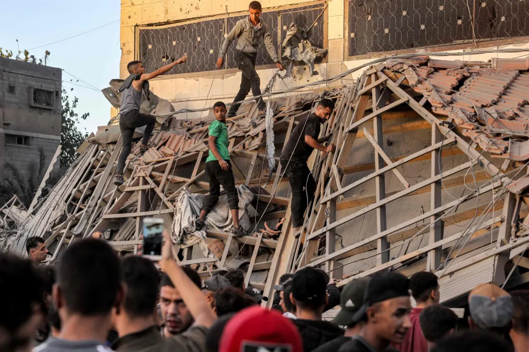 فلسطينيون يبحثون عن ناجين تحت الأنقاض بأحد المباني التي تعرضت للقصف