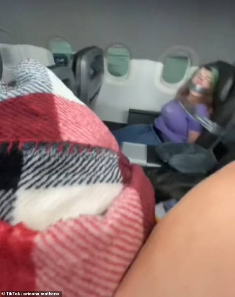 شاهد: تقييد مسافرة أمريكية ووضع شريط لاصق على مقعدها وفمها بعد محاولتها فتح باب الطائرة