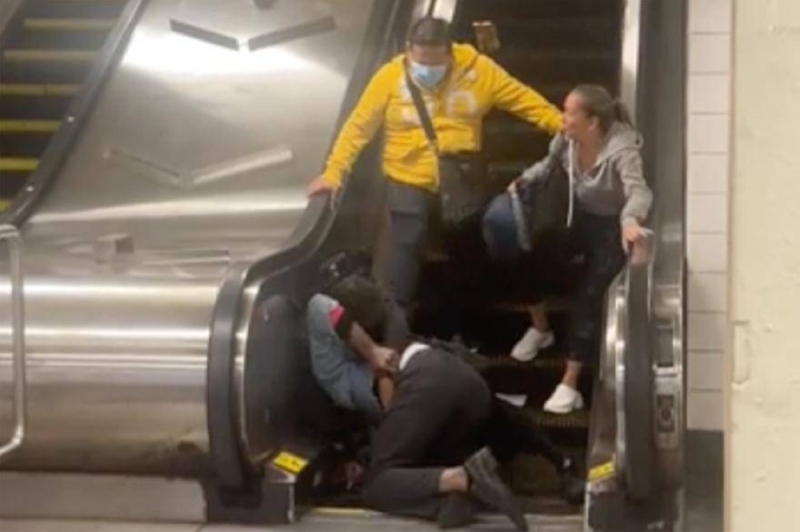 تدحرجا سوياً.. شاهد: شجار عنيف بين رجلين أعلى سلم كهربائي في محطة مترو بأمريكا
