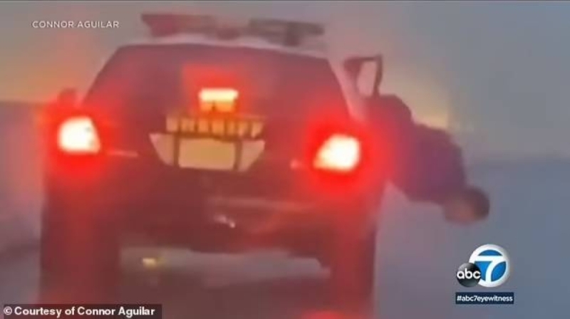 شاهد .. أمريكي مقيد اليدين يحاول القفز من سيارة شرطة محاولا الهرب في لوس أنجلوس
