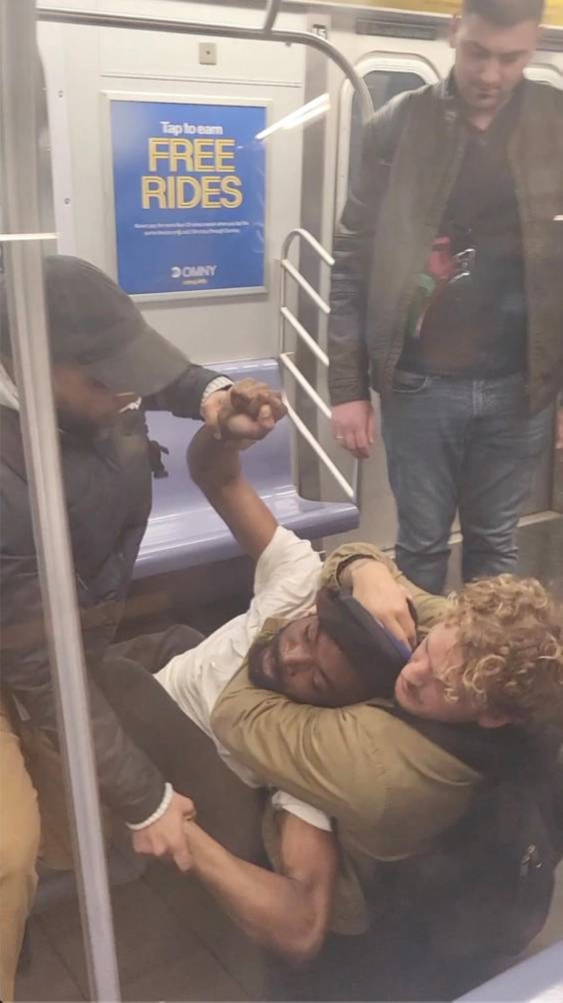 شاهد..   جندي أمريكي في "المارينز " يخنق مشرد أسود حتى الموت داخل قطار في نيويورك